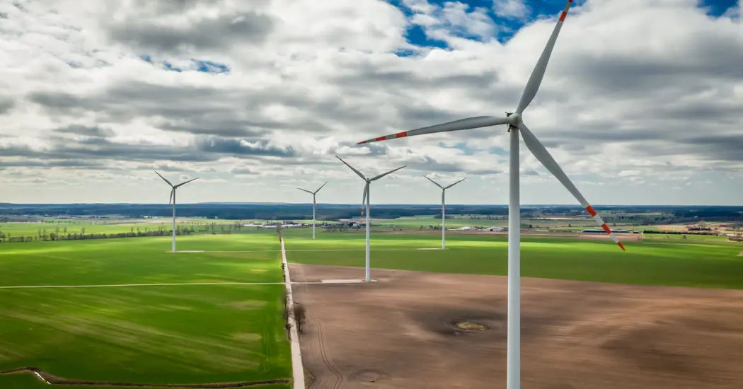 image is White Wind Turbines In A Field Poland From Above 2023 11 27 04 54 58 Utc
